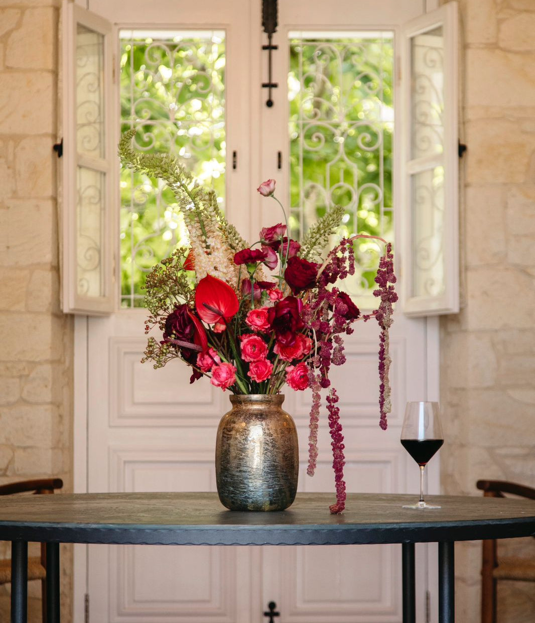 Red and burgundy floral arrangement in a vase