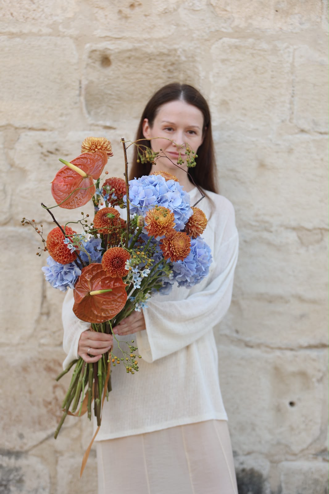 Terra & Sky designer bouquet with blue hydrangeas and warm orange flowers